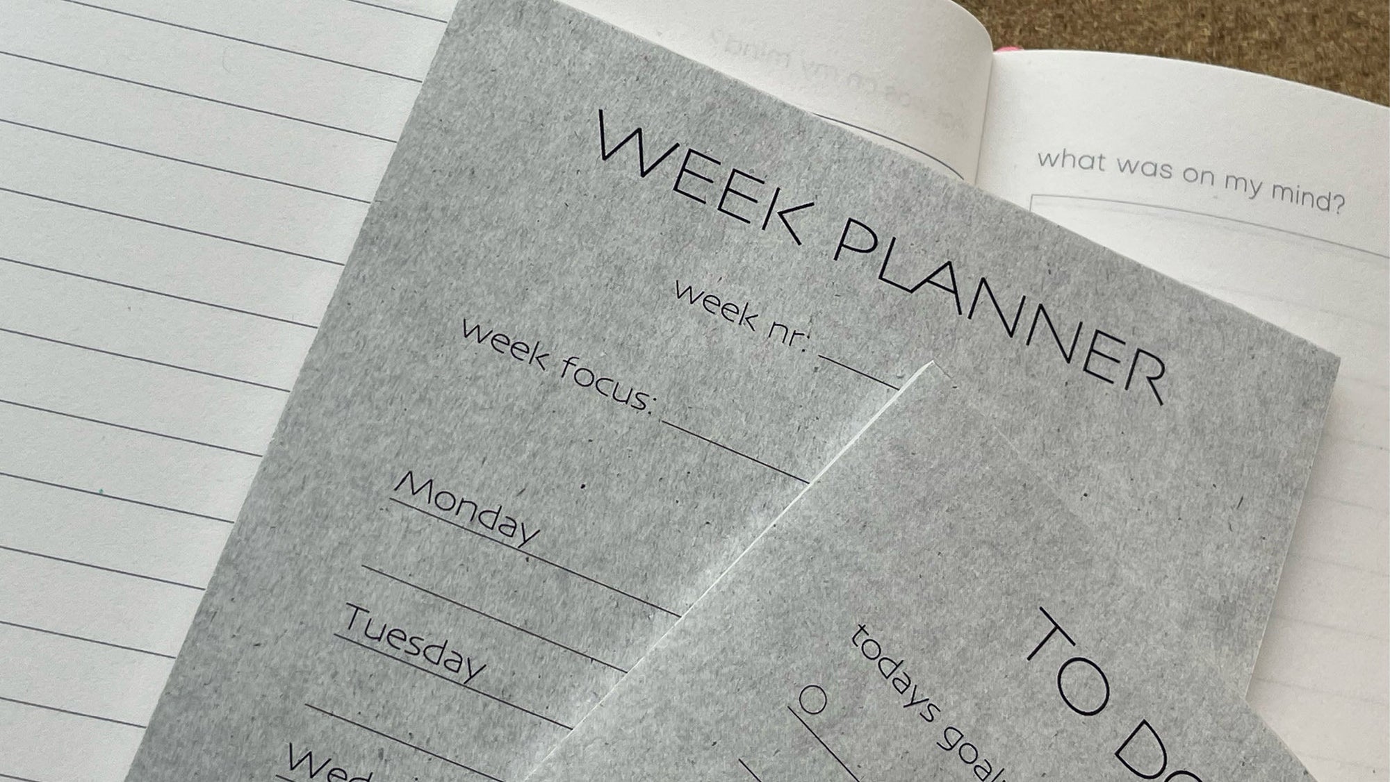Open recycled paper weekly planner notebook showing a Week Planner page with lined sections for Monday to Tuesday and a To Do list page on the right