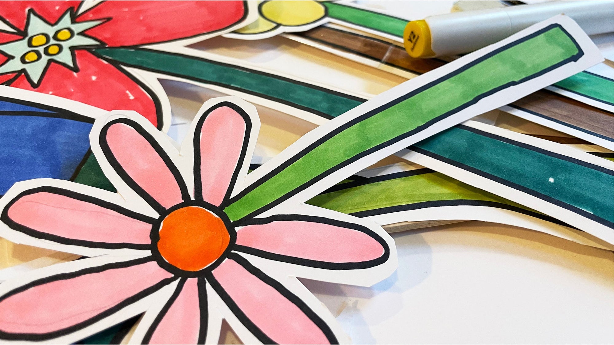 hand-drawn paper flower cut-outs with pink petals, green stems and black outlines, flat lay, loose pieces