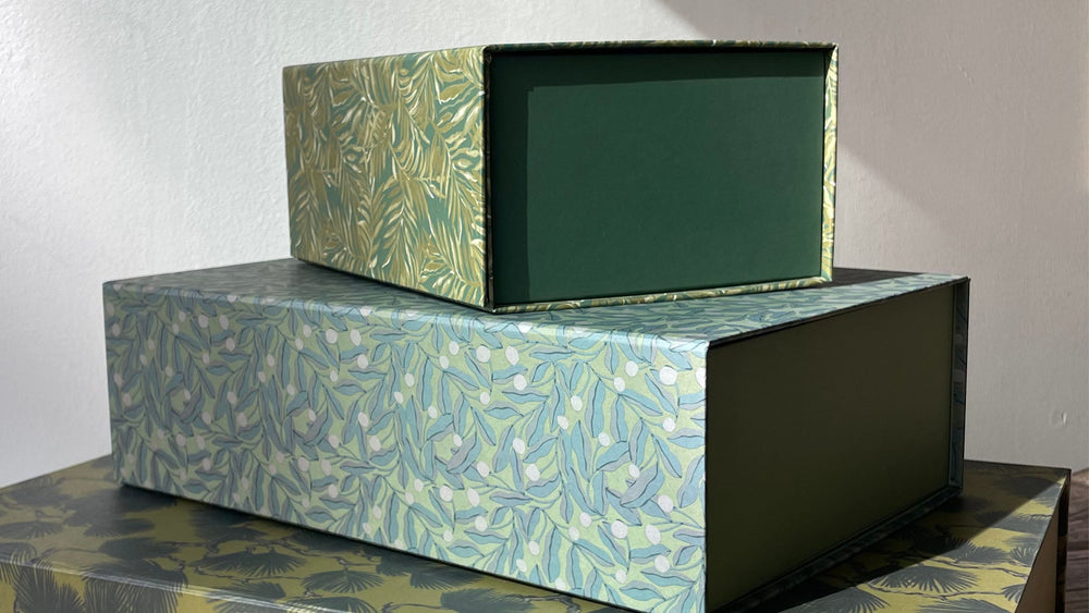 Stacked rectangular desk storage boxes with botanical leaf pattern in green and blue tones, open-front design showing solid green interior