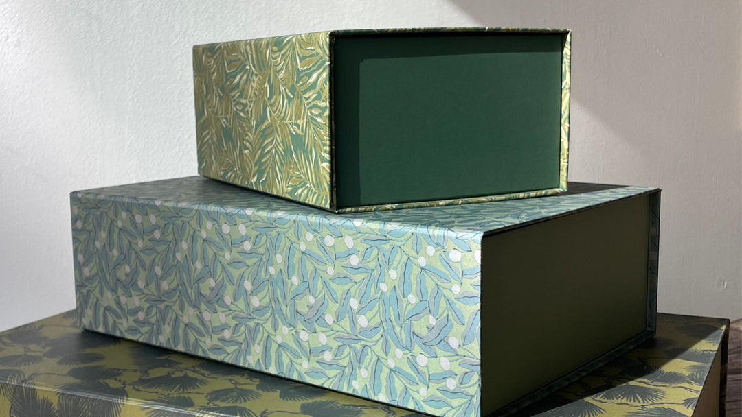 Stacked rectangular desk storage boxes with botanical leaf pattern in green and blue tones, open-front design showing solid green interior