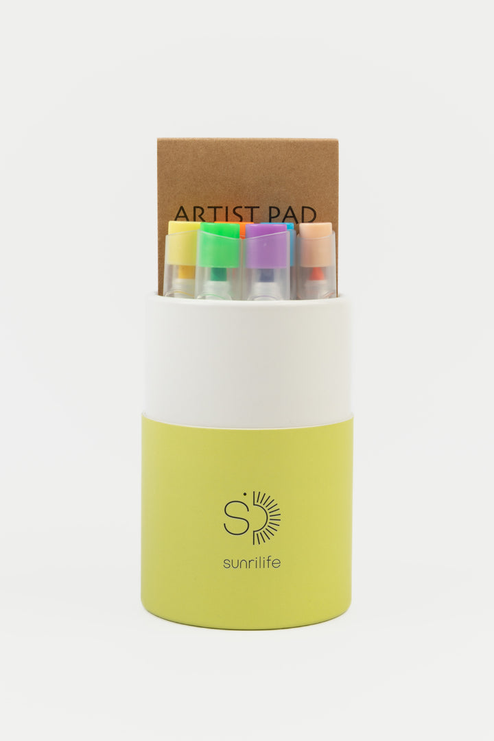 Open recycled cardboard yellow and white tube showing 12 highlighters and a small artist pad