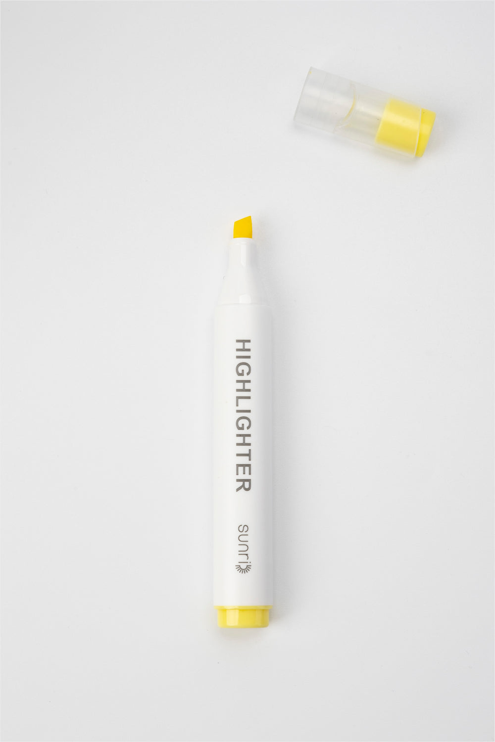 White highlighter pen with yellow cap and body on a white background