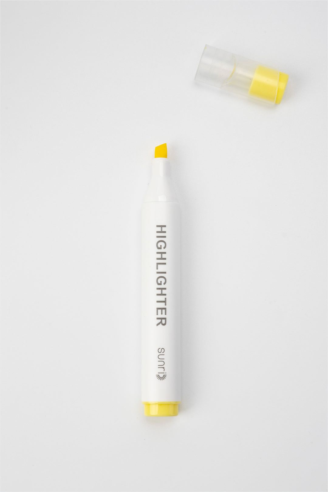 White highlighter pen with yellow cap and body on a white background