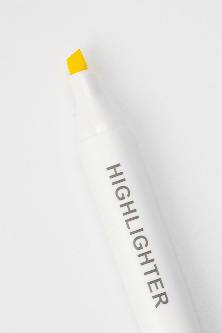White highlighter pen with yellow cap on a white background