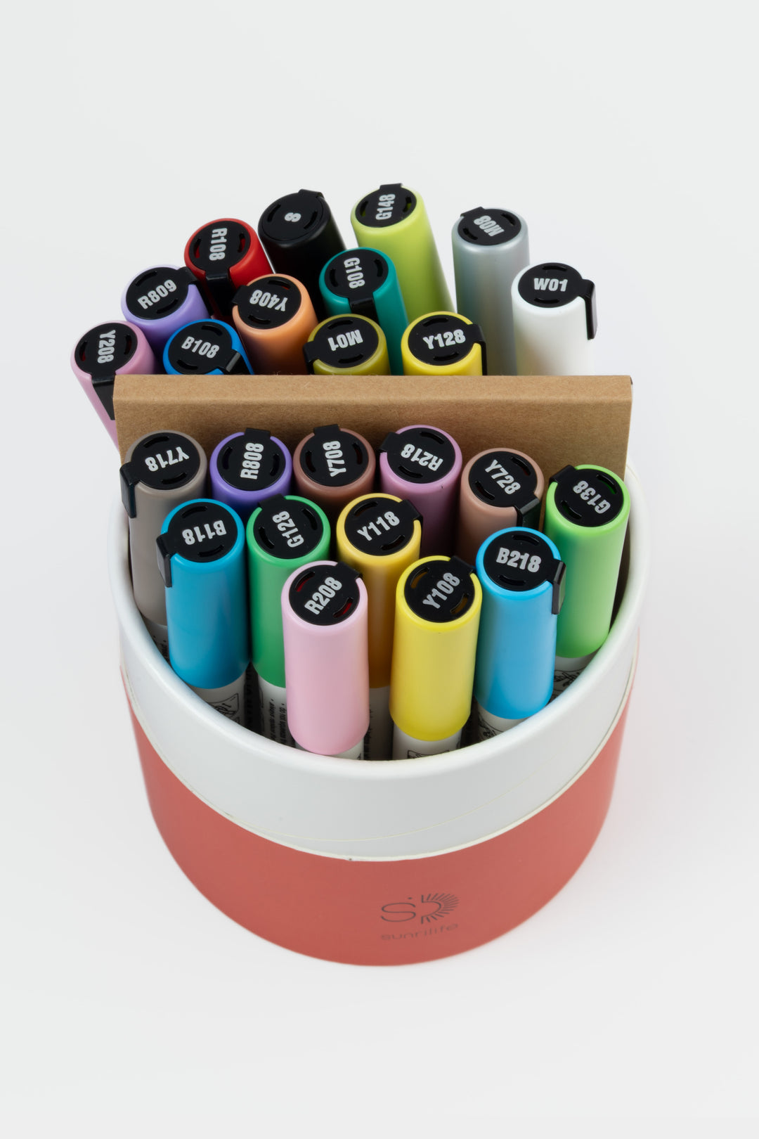 Open recycled cardboard red tube showing assorted acrylic markers and an artist pad
