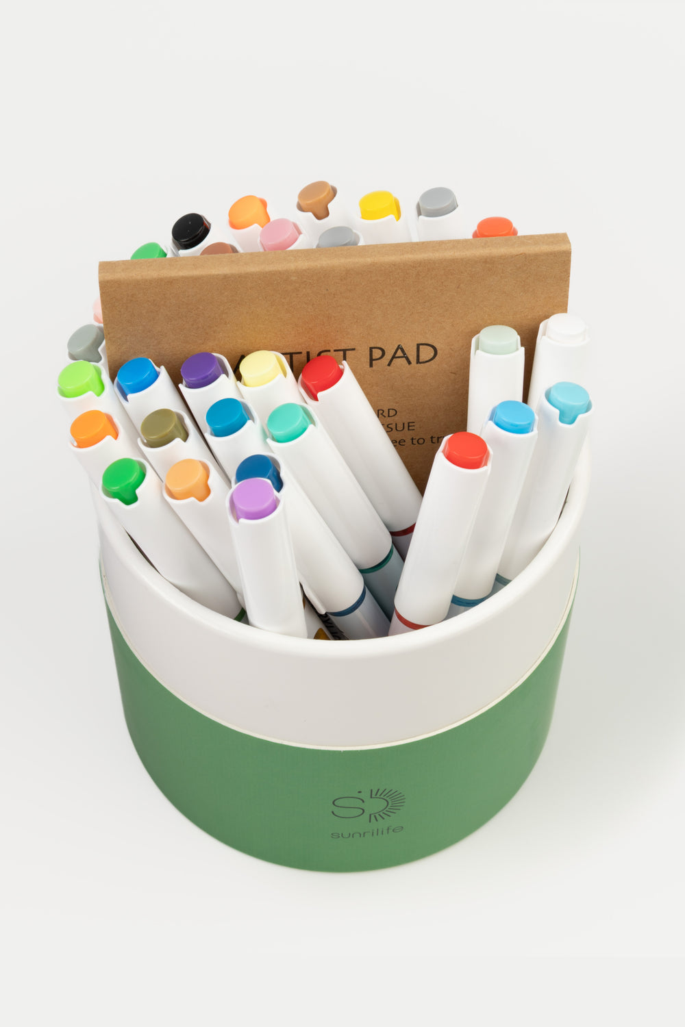 Open recycled cardboard green tube showing assorted acrylic brush markers and an artist pad
