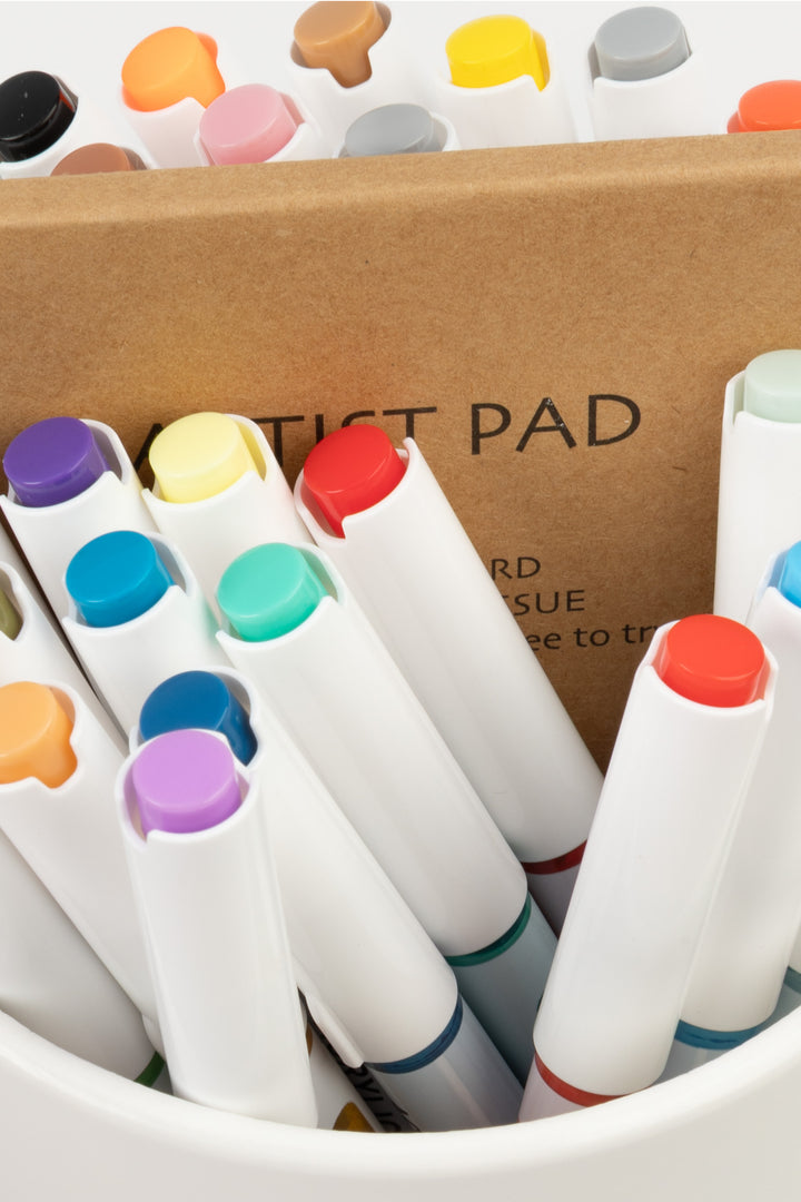 acrylic brush markers grouped upright in holder, multicolour caps visible