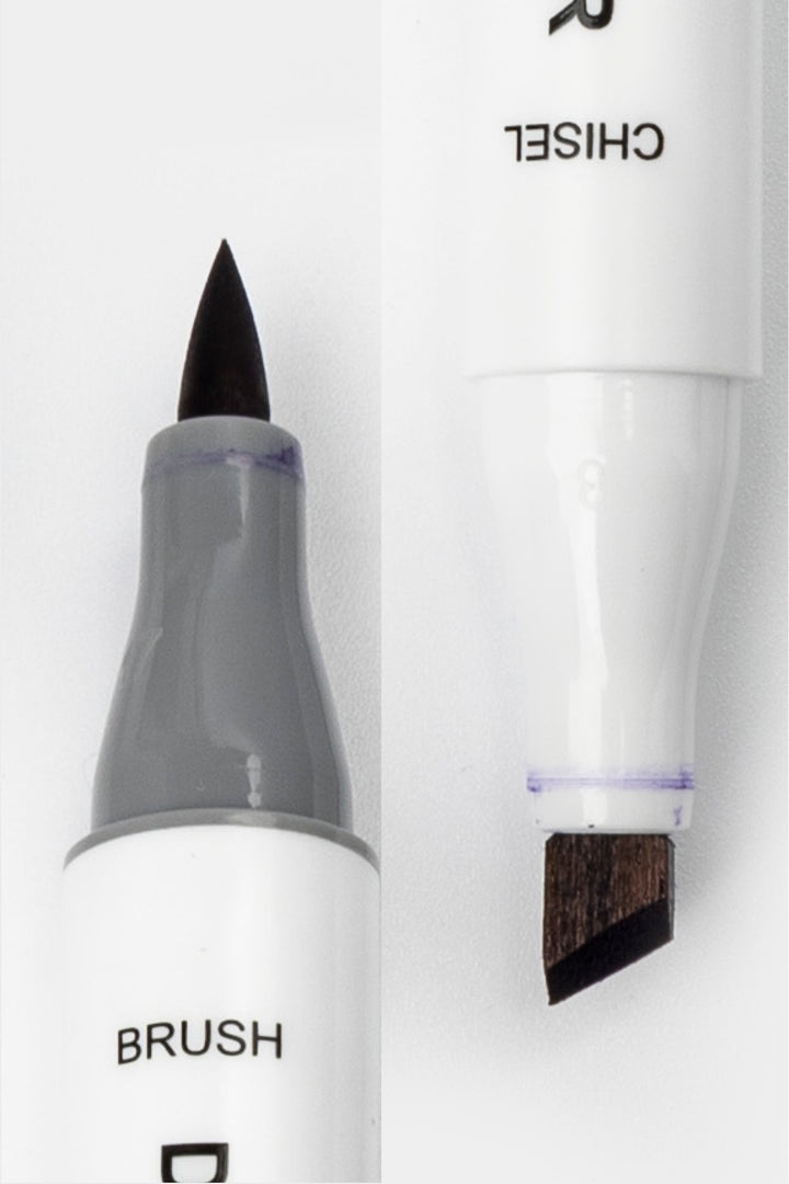 Close-up of dual tip art marker showing brush tip and angled chisel tip ends
