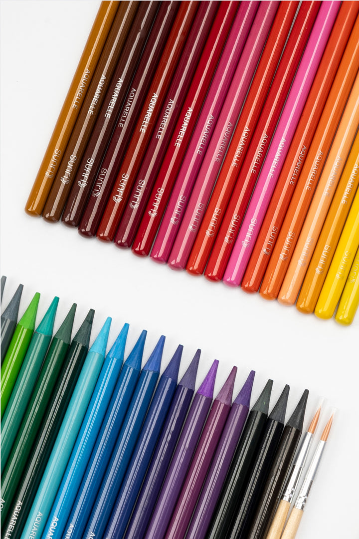 36 woodless aquarelle pencils arranged by colour range from green and blue to red and yellow
