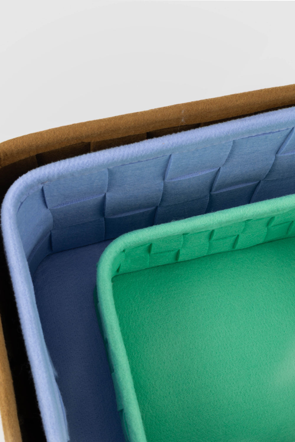 close-up of the interiors of the woven felt storage boxes highlighting the soft felt texture and woven construction
