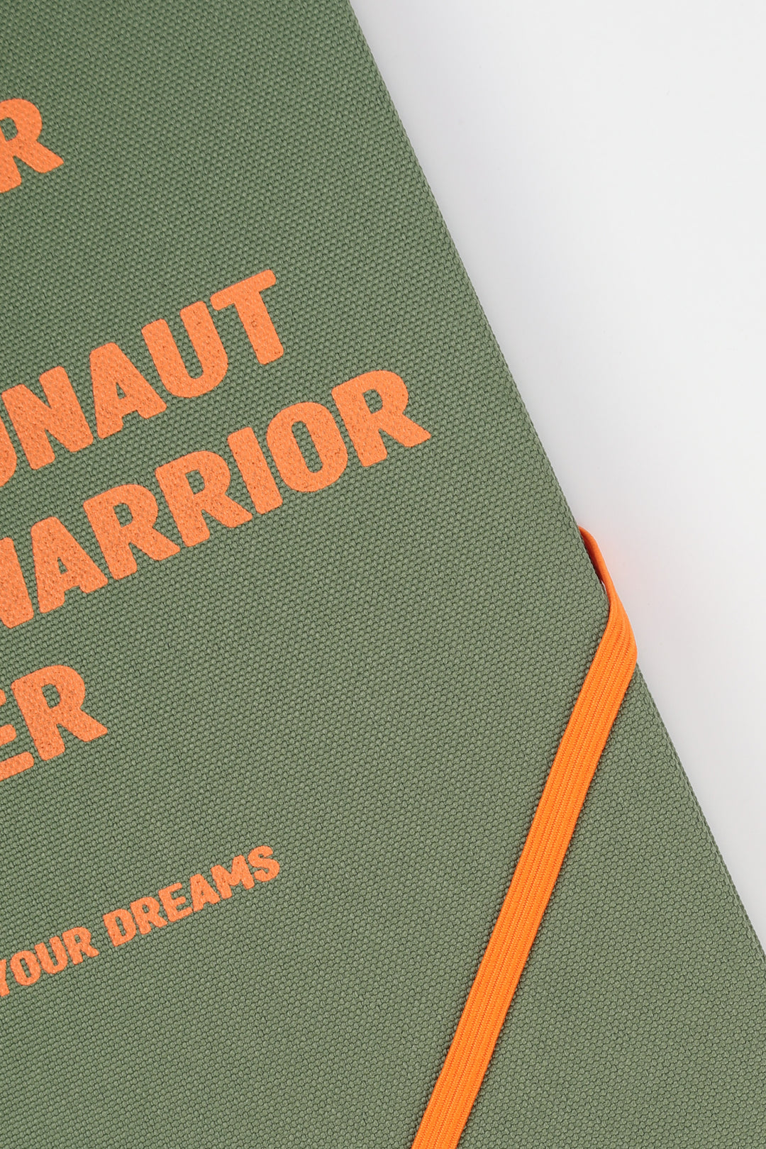 Close-up of green fabric cover with orange text and orange elastic band
