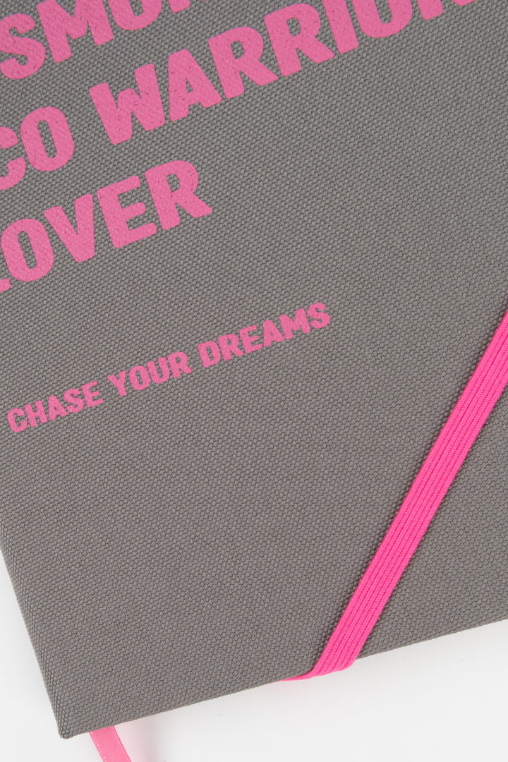 Close-up of grey fabric cover with pink text and pink elastic band