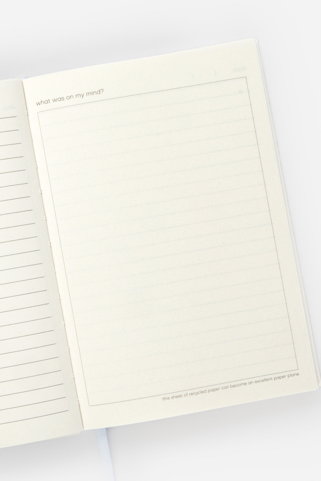 open diary with lined page left and blank doodle page on the right