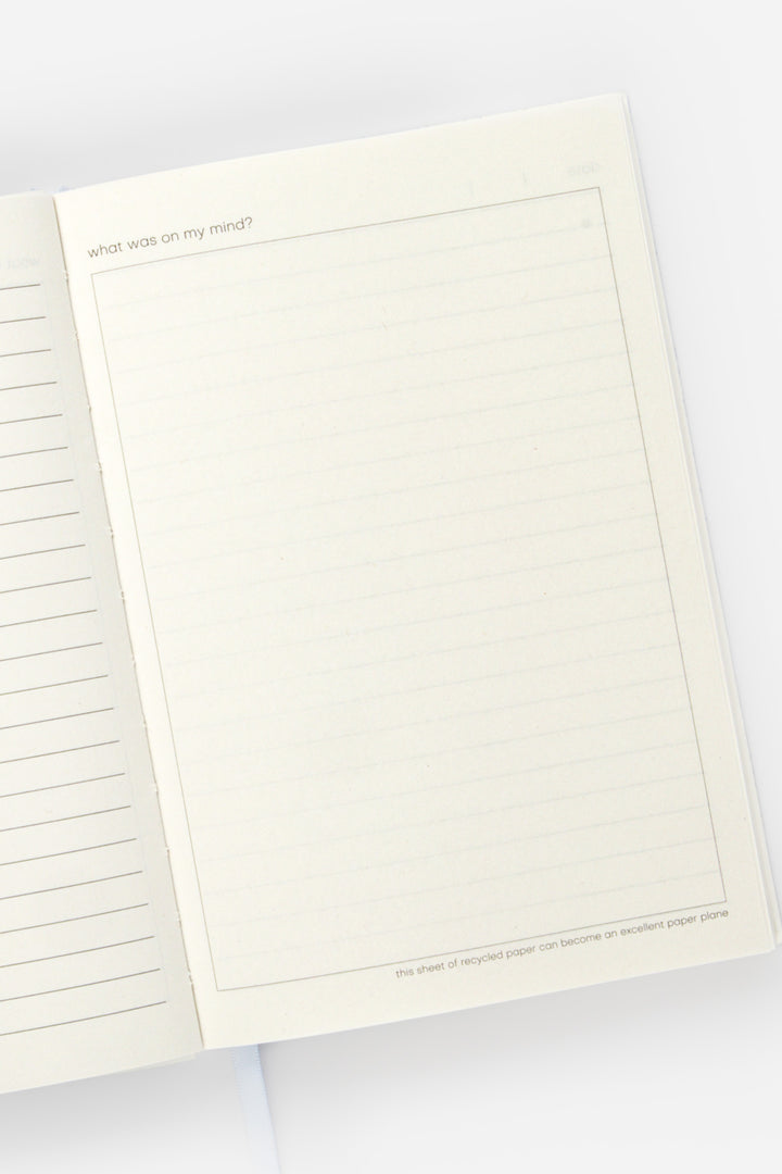 open diary with lined page left and blank doodle page on the right