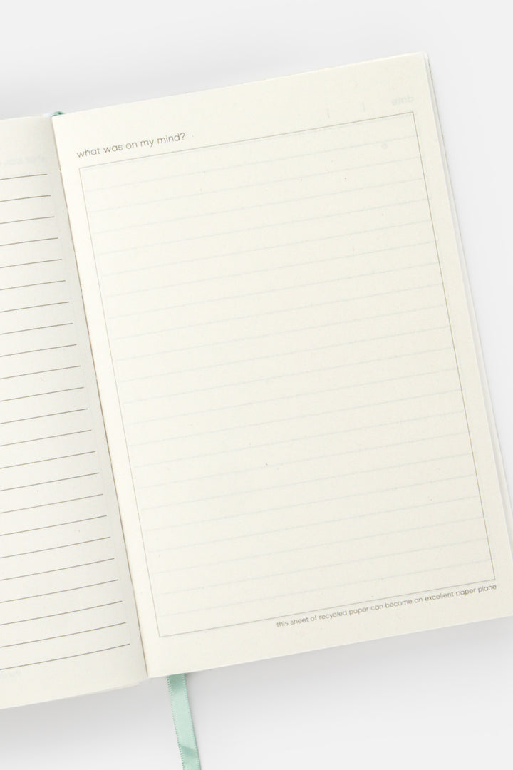 open diary with lined pages on the left and blank doodle page on the right