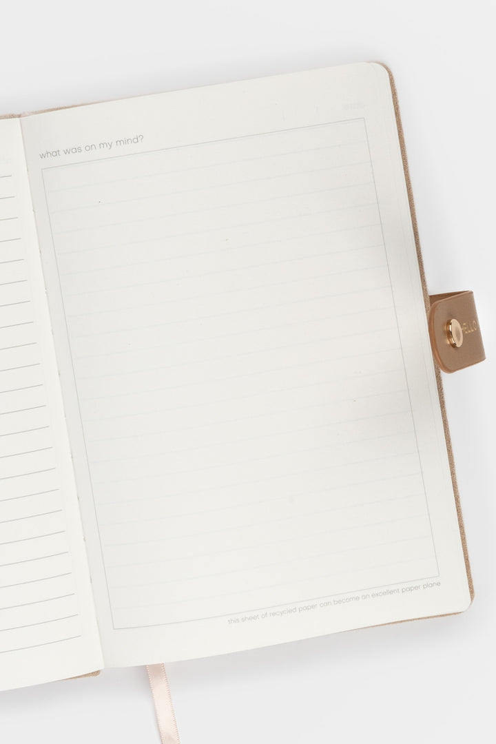 open diary showing lined pages with a flap closure and ribbon marker visible on the right side