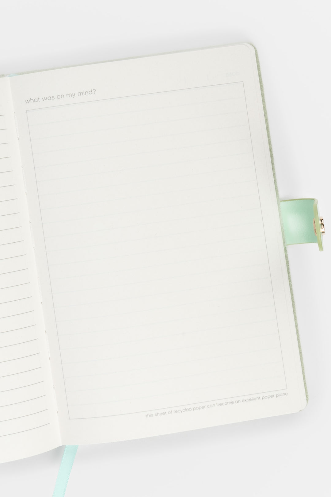 open diary showing lined pages with a flap closure and ribbon marker visible on the right side