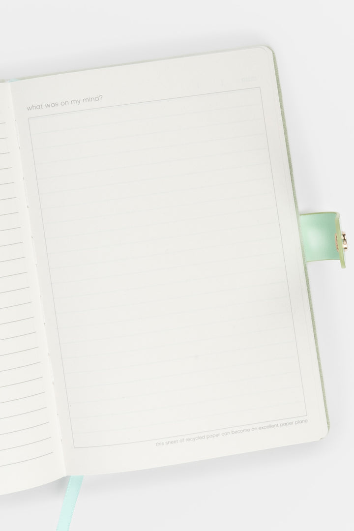 open diary showing lined pages with a flap closure and ribbon marker visible on the right side