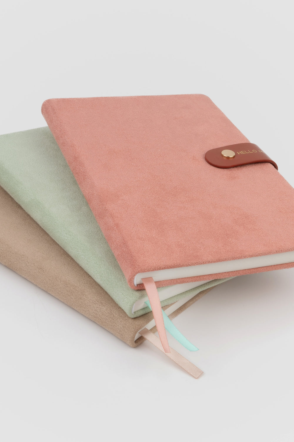 stack of faux-suede notebooks with flap closures and matching satin page markers