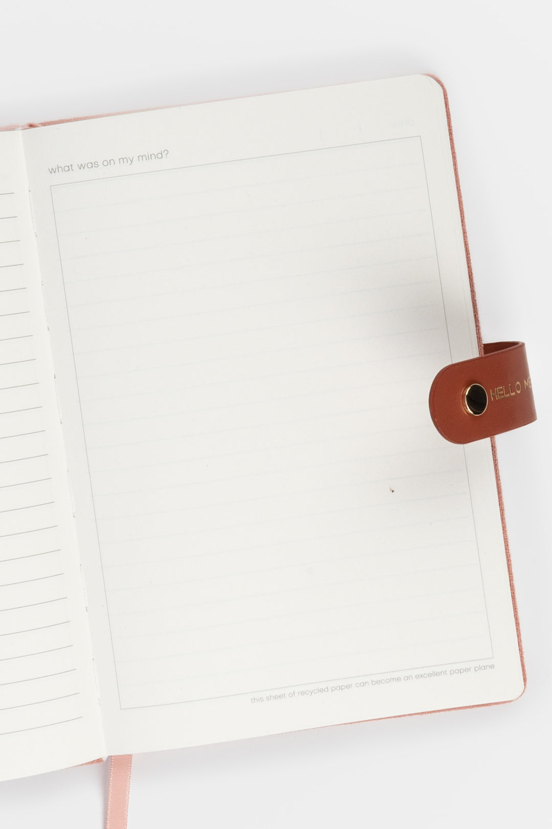 open diary showing lined pages with a flap closure and ribbon marker visible on the right side