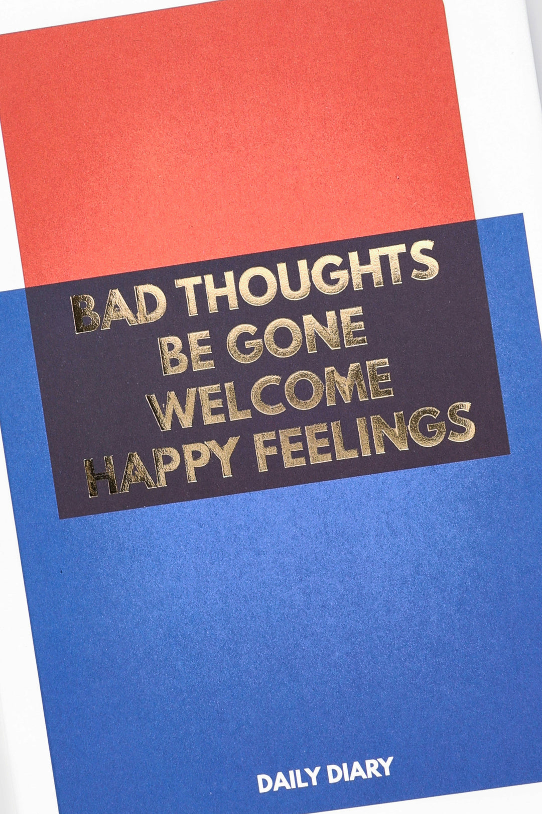 detail of gold foil text on red navy and blue colour-block diary cover
