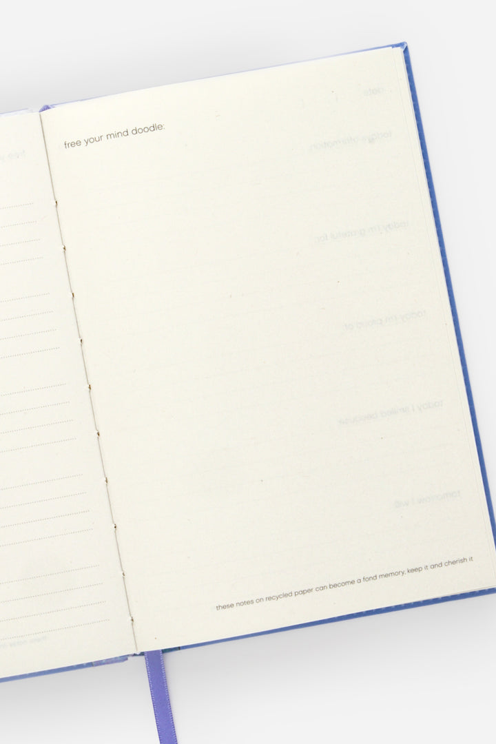 open planner showing a blank doodle page and pink ribbon marker at the bottom
