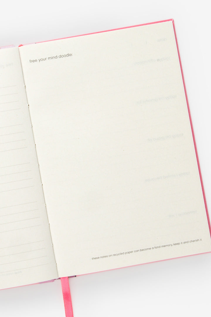 open planner showing a blank doodle page and pink ribbon marker at the bottom
