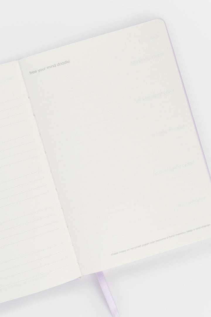 open journal showing lined pages on the left and a blank doodle page on the right