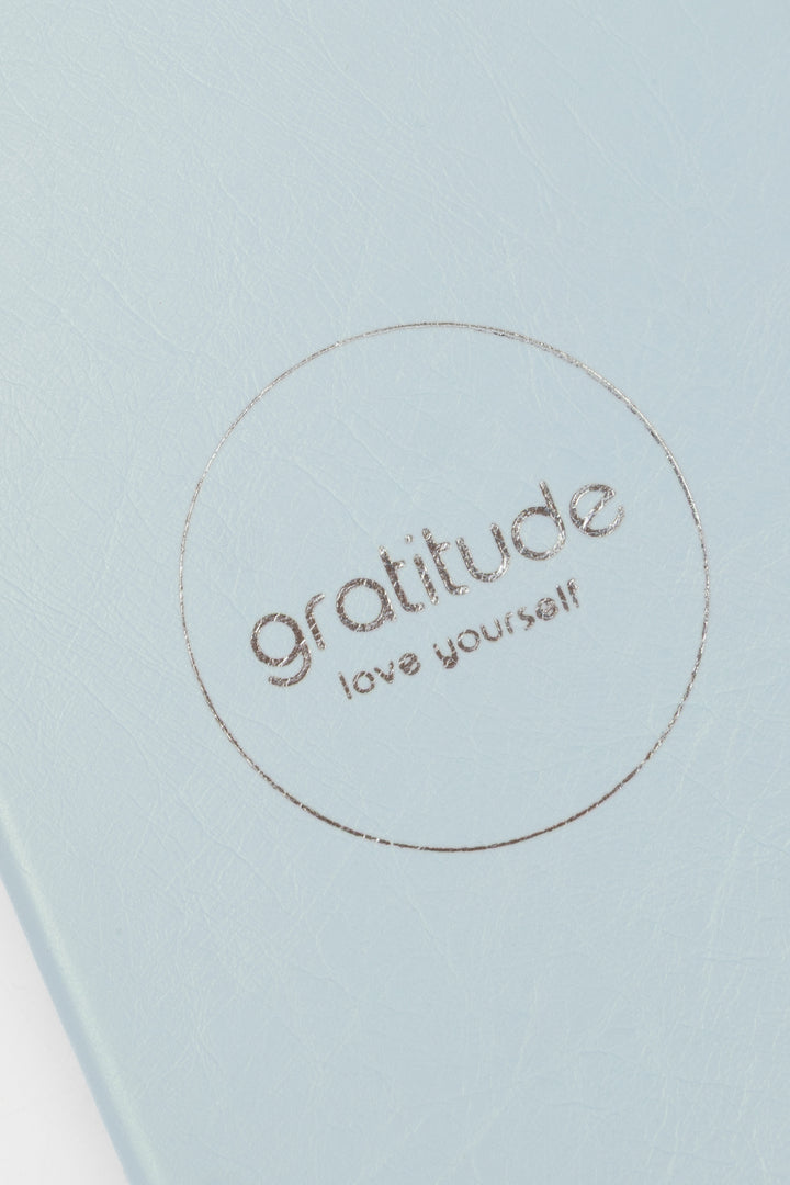 Light blue journal cover with 'gratitude love yourself' embossed text 