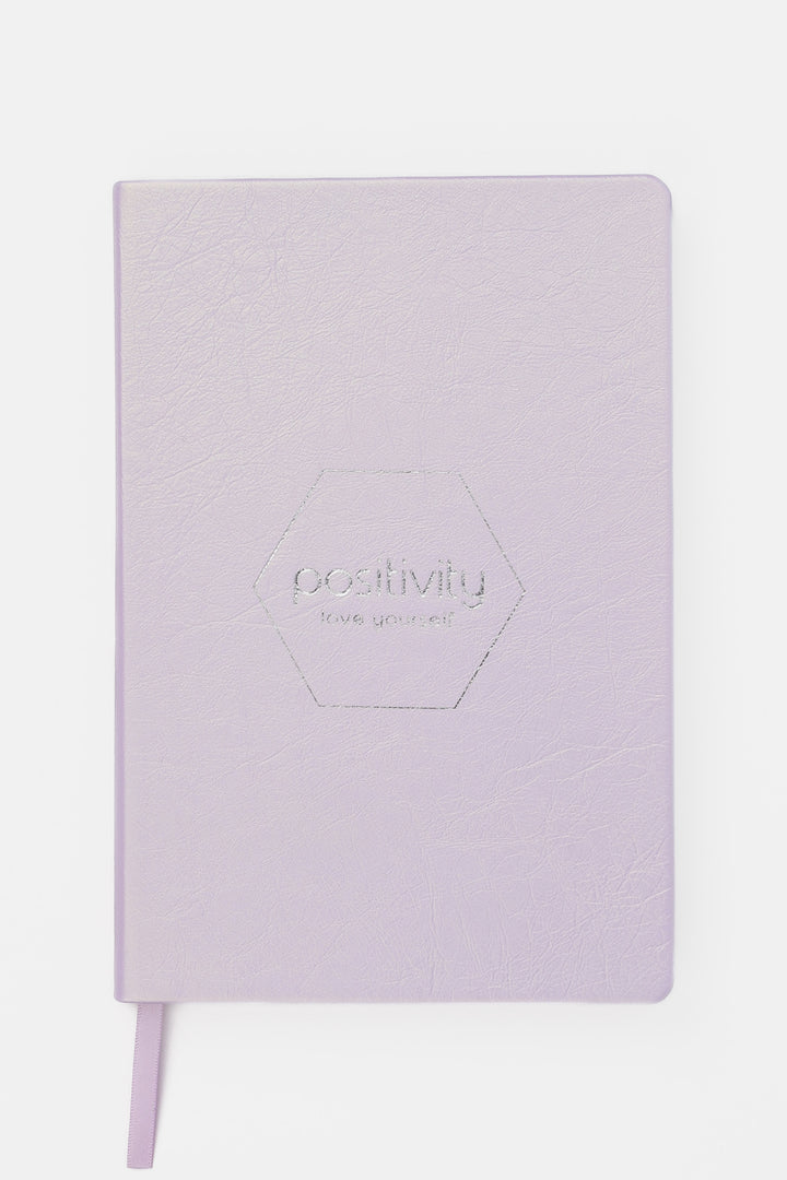 Pink notebook with 'positivity' embossed on the cover 