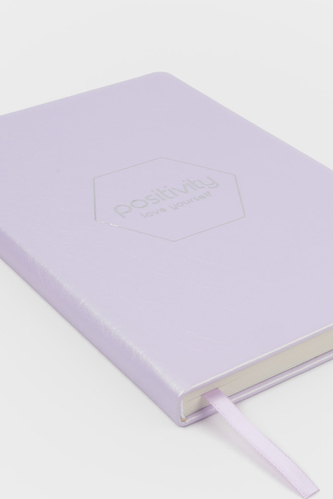 pink notebook with 'positivity' embossed on the cover 