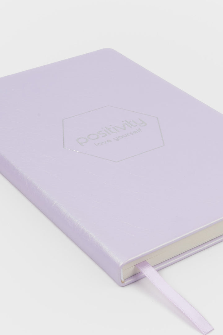 pink notebook with 'positivity' embossed on the cover 