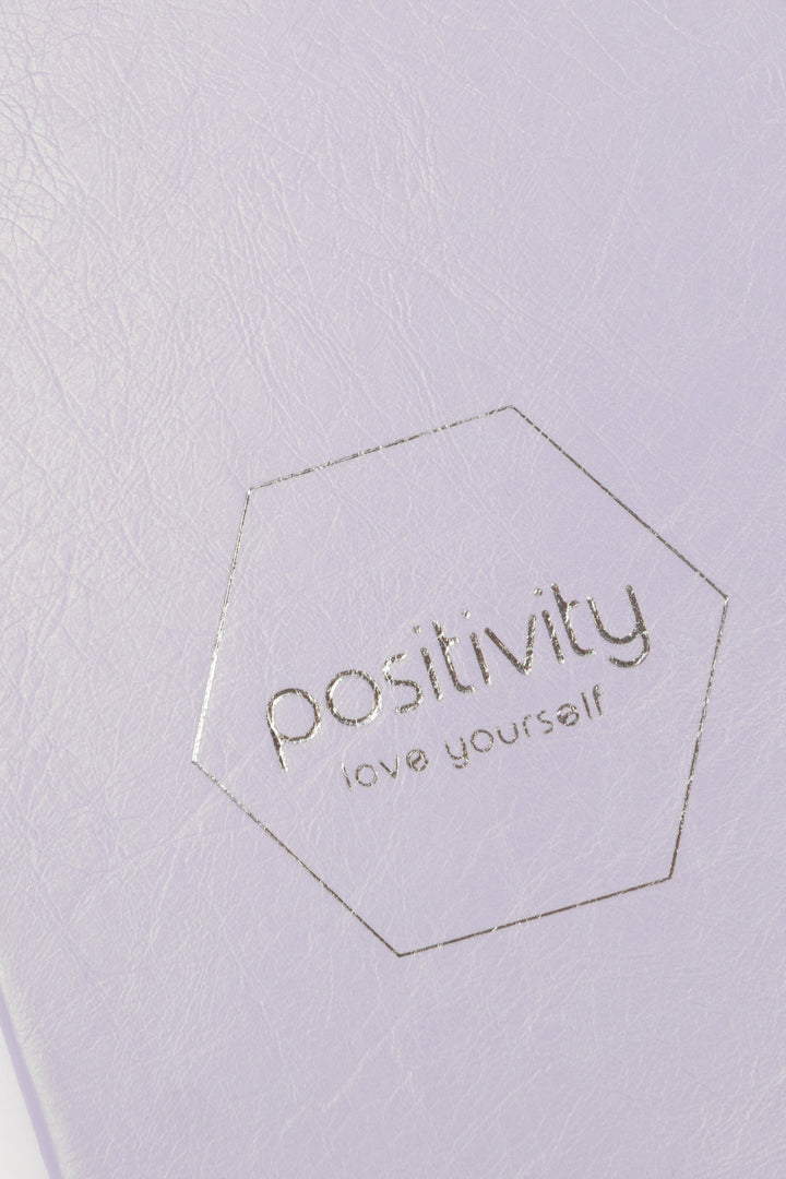 Hexagonal logo with 'positivity love yourself' text on a pink journal cover