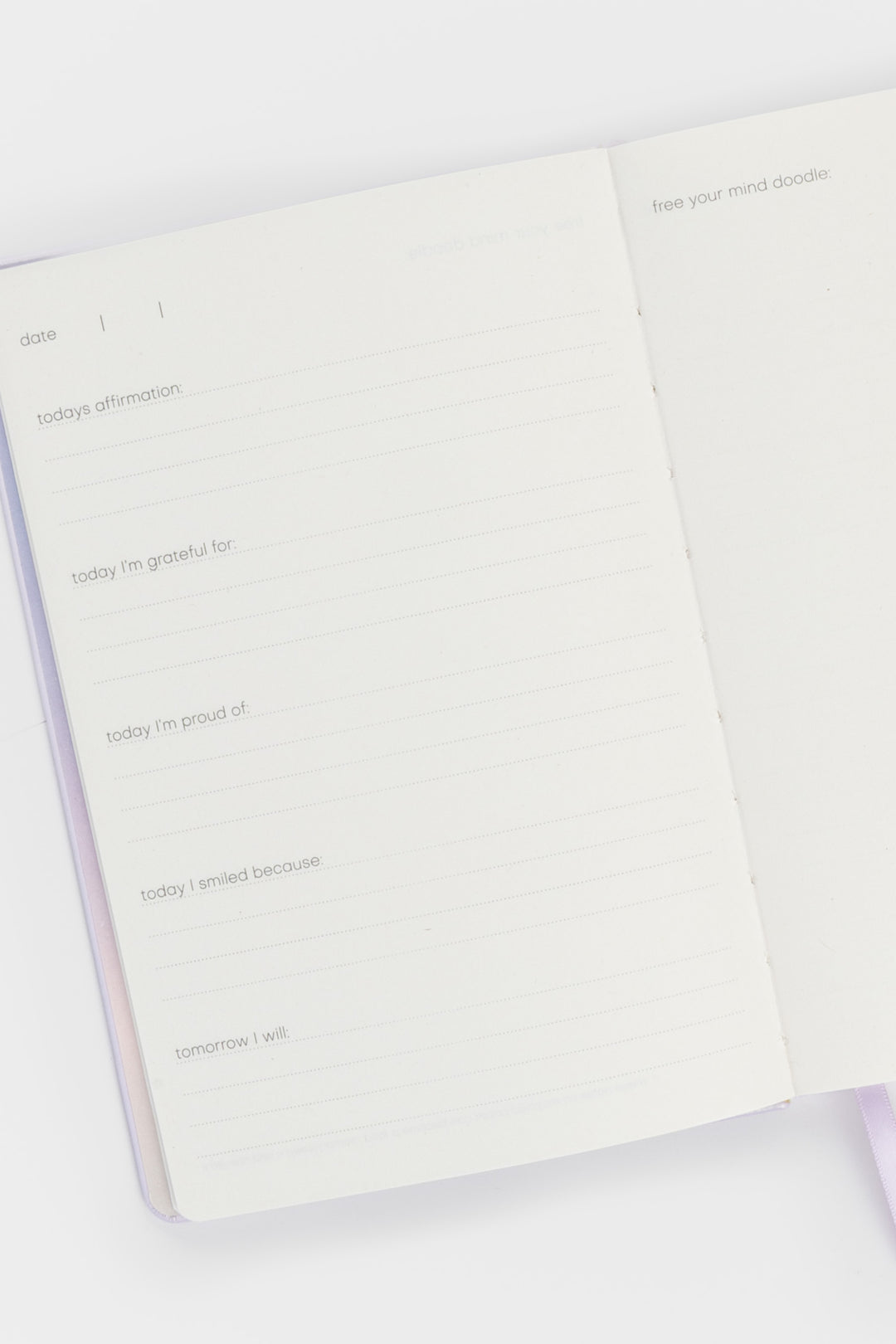 open journal showing lined pages with daily prompts on the left and a blank doodle page on the right