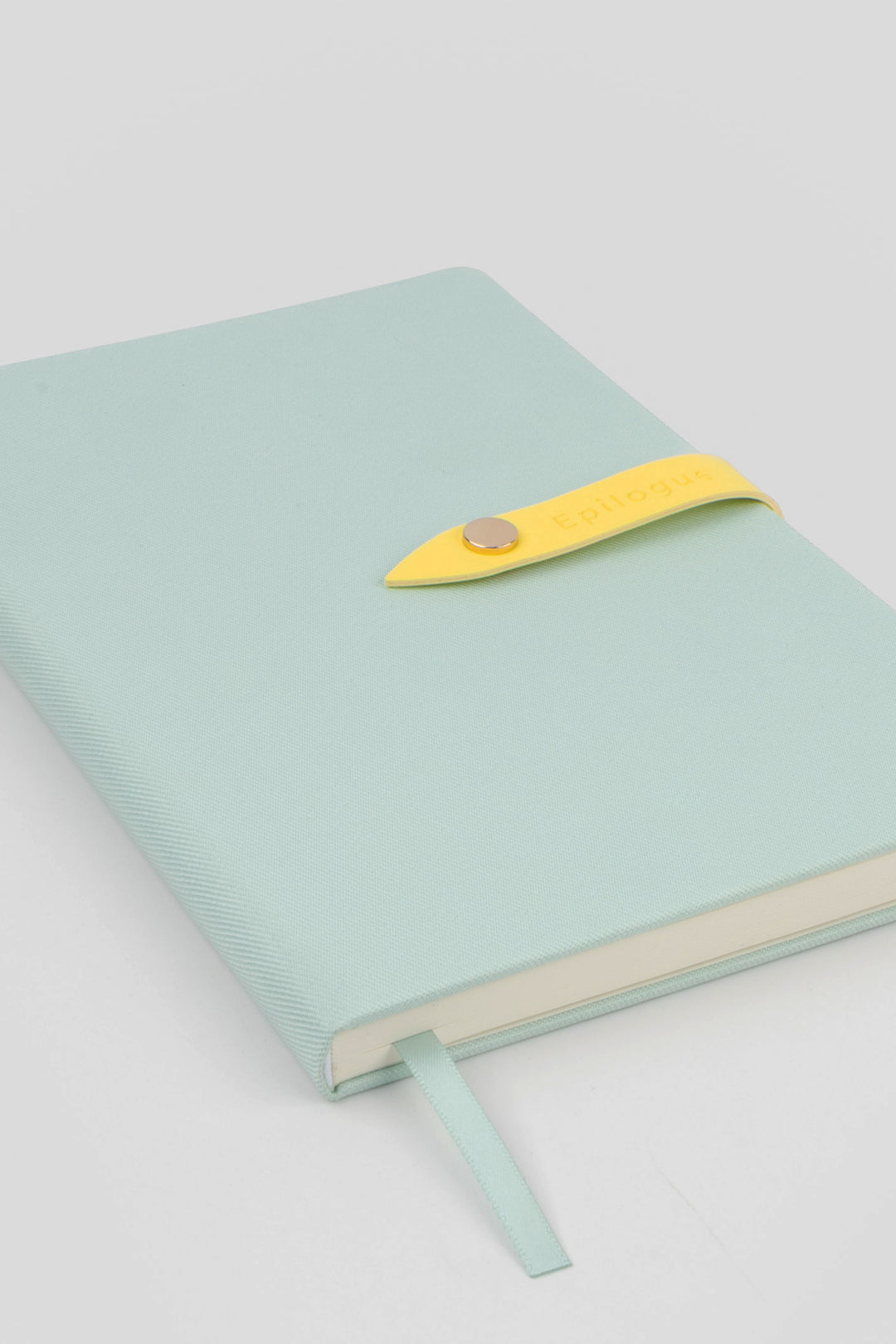 mint coloured journal with a yellow strap and metal push button