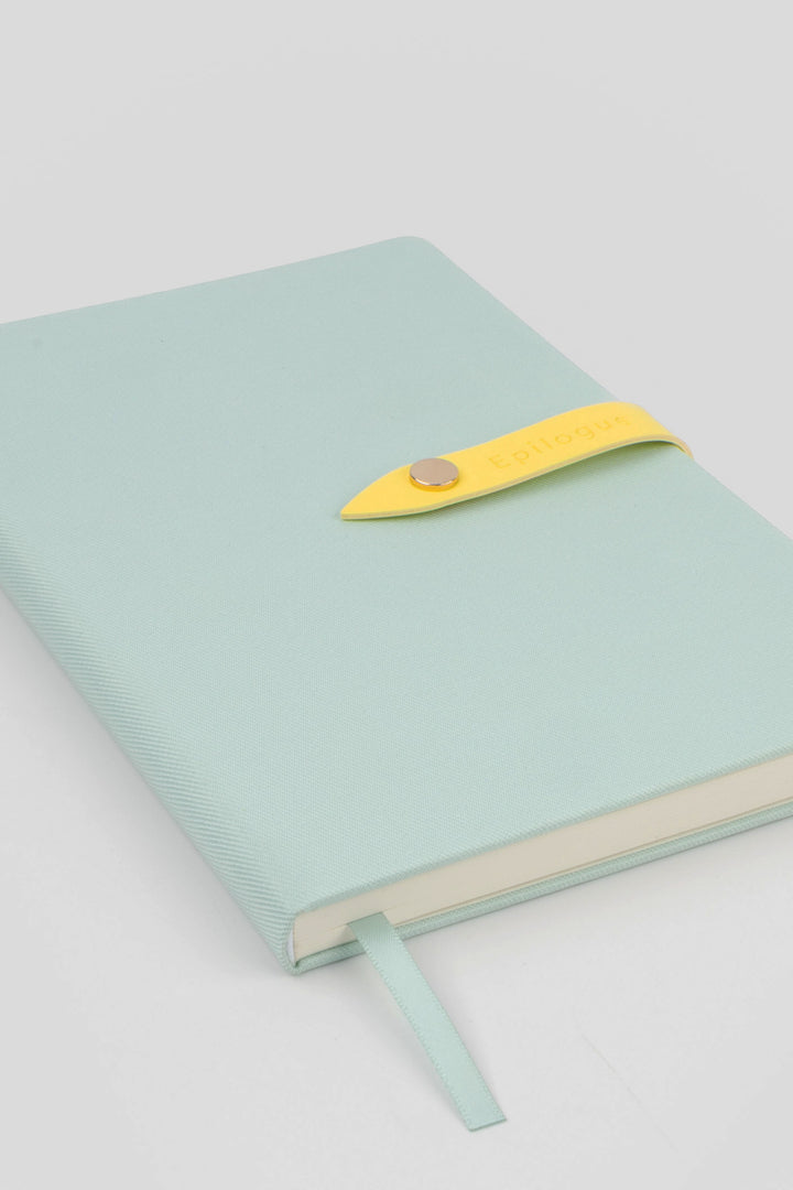 mint coloured journal with a yellow strap and metal push button