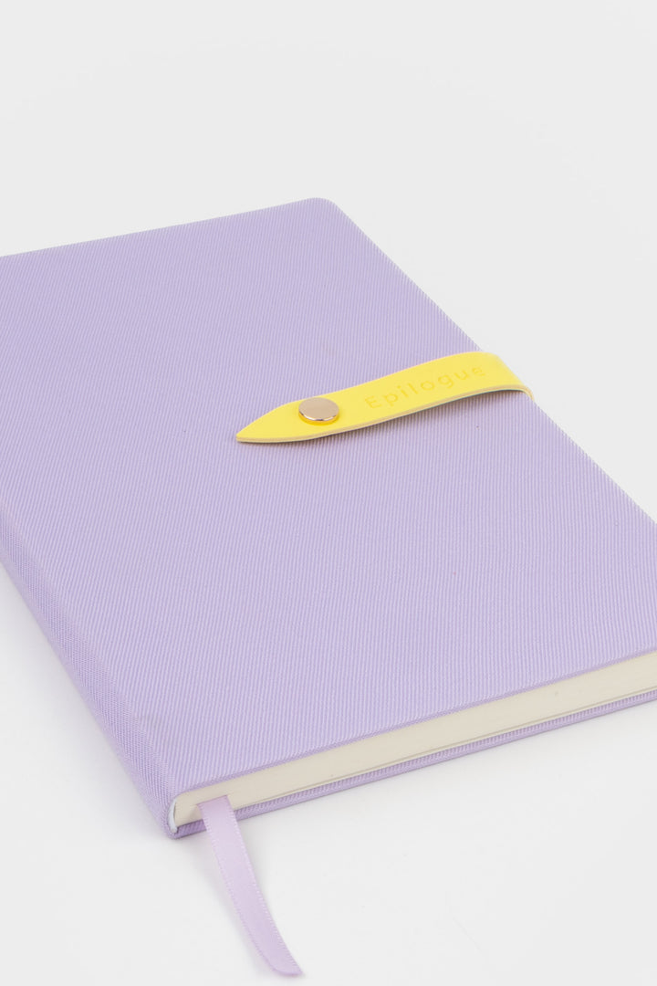 purple journal with a yellow strap and metal push button