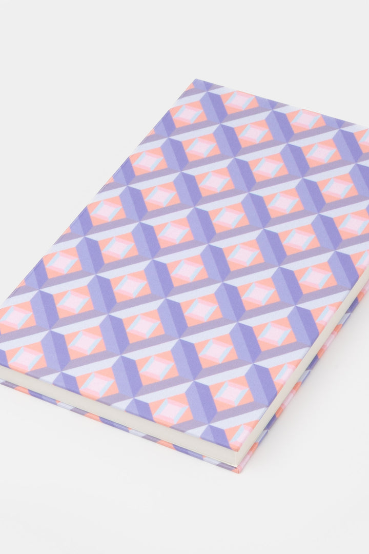 A5 hardcover notebook with pink and purple optical geometric print shown closed
