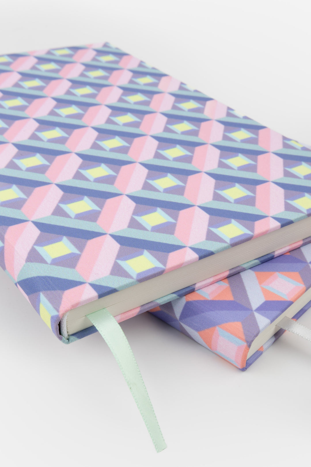 Two A5 optical print notebooks side by side, one pink and purple, one multicolour
