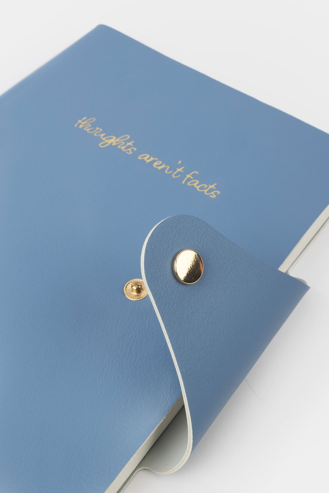 Blue notebook with gold text and button on a light gray background