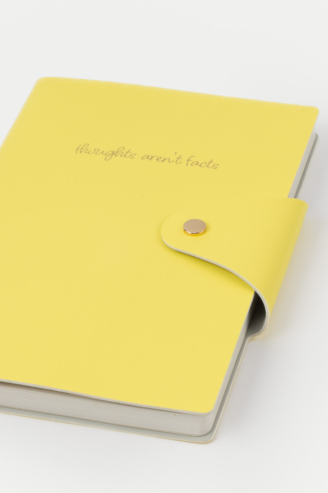 Yellow notebook with a button closure on a white background