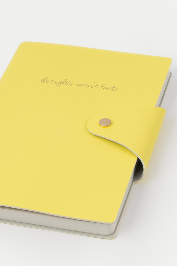 Yellow notebook with a button closure on a white background