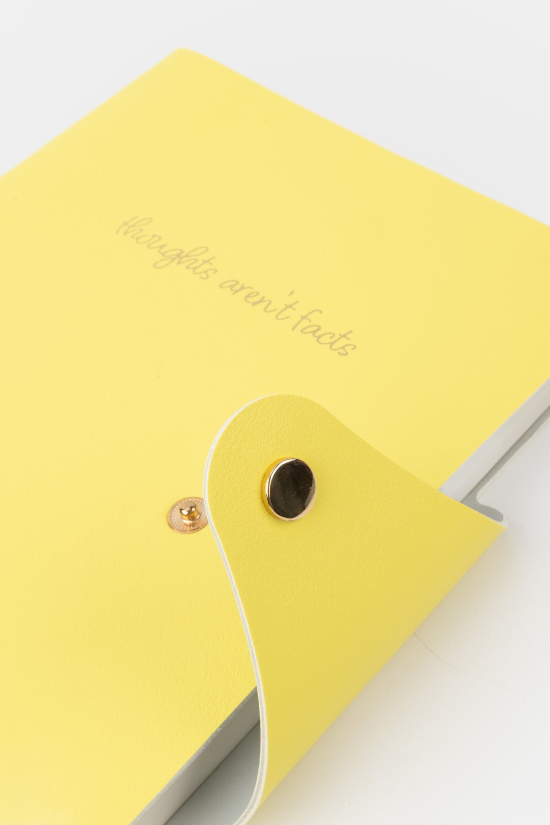 Yellow notebook with a decorative flap on a light gray background