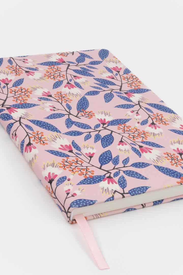 notebook with a pink floral cover shown at an angle with a matching ribbon marker
