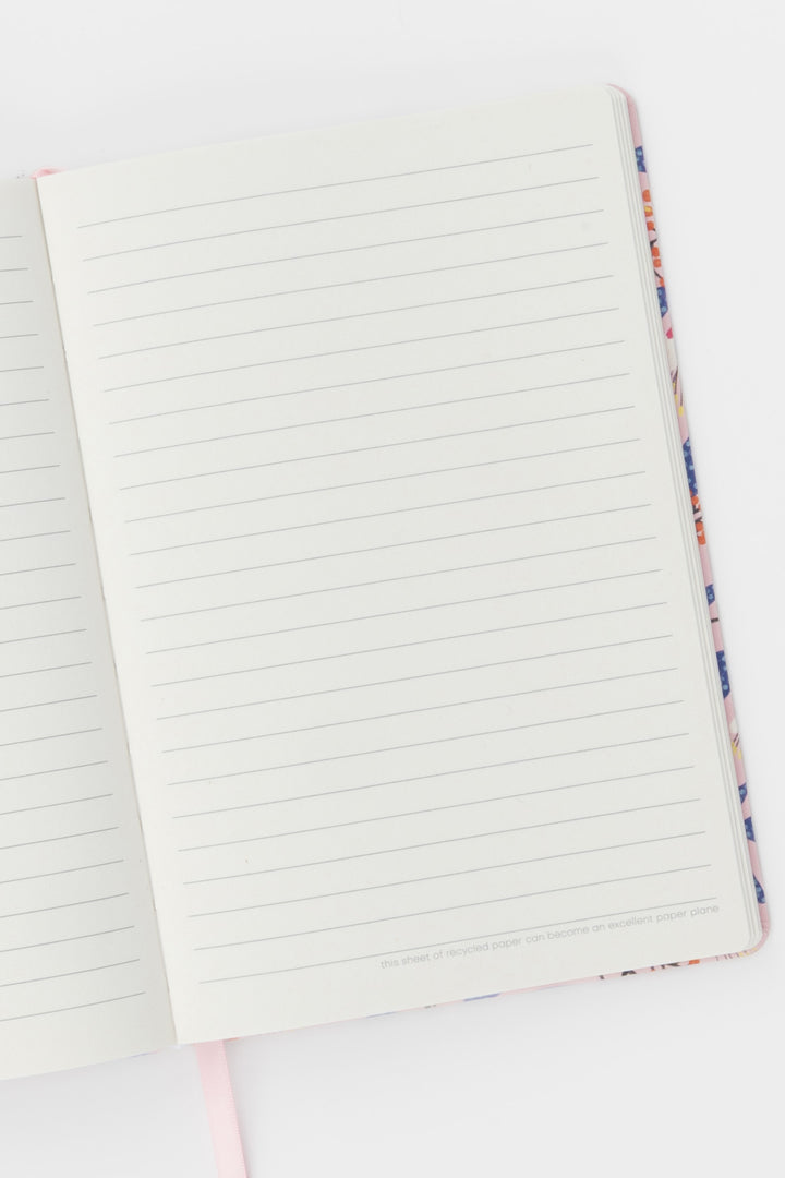open notebook showing ruled pages with the pink ribbon marker visible at the bottom
