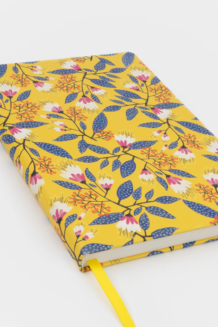 notebook with a yellow floral cover shown at an angle with a matching ribbon marker

