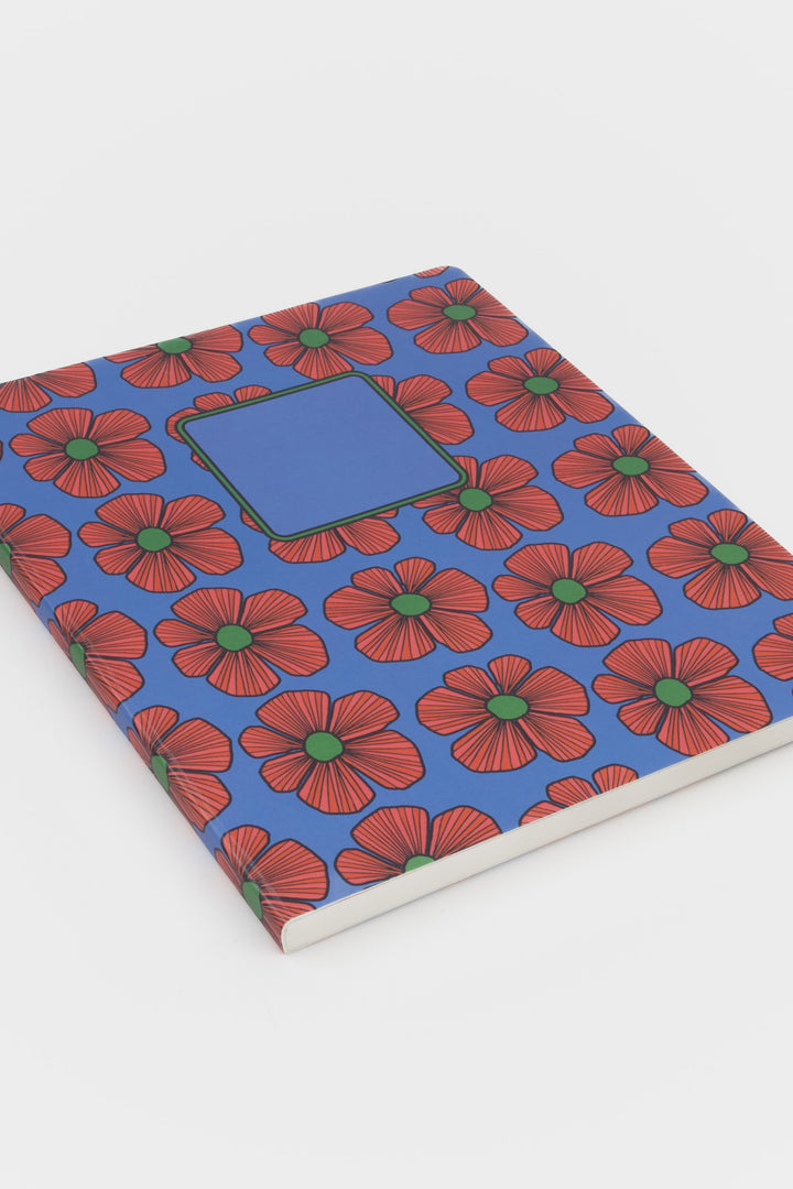 Notebook with red floral pattern on a blue background