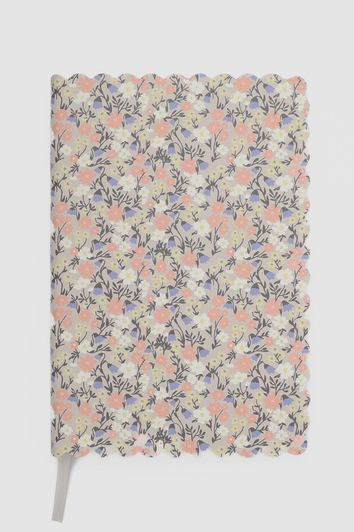 front view of a scalloped-edge notebook with an all-over small flower pattern in pastel colours