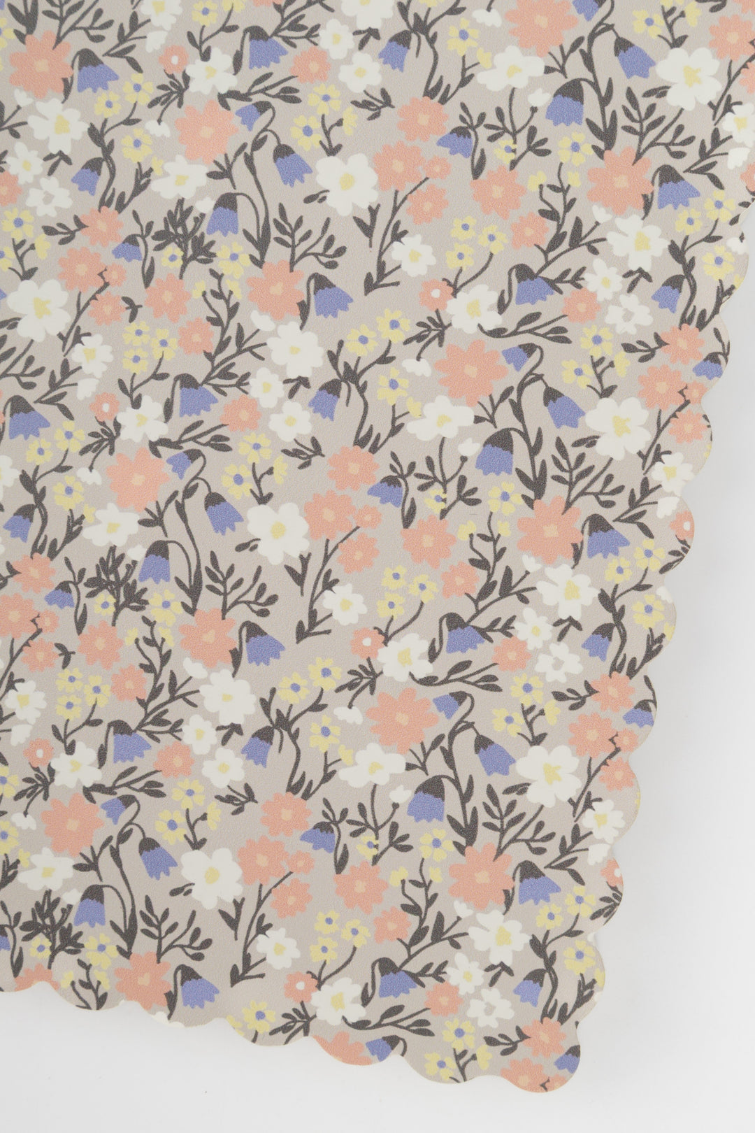 detail of a scalloped-edge notebook with an all-over small flower pattern in pastel colours