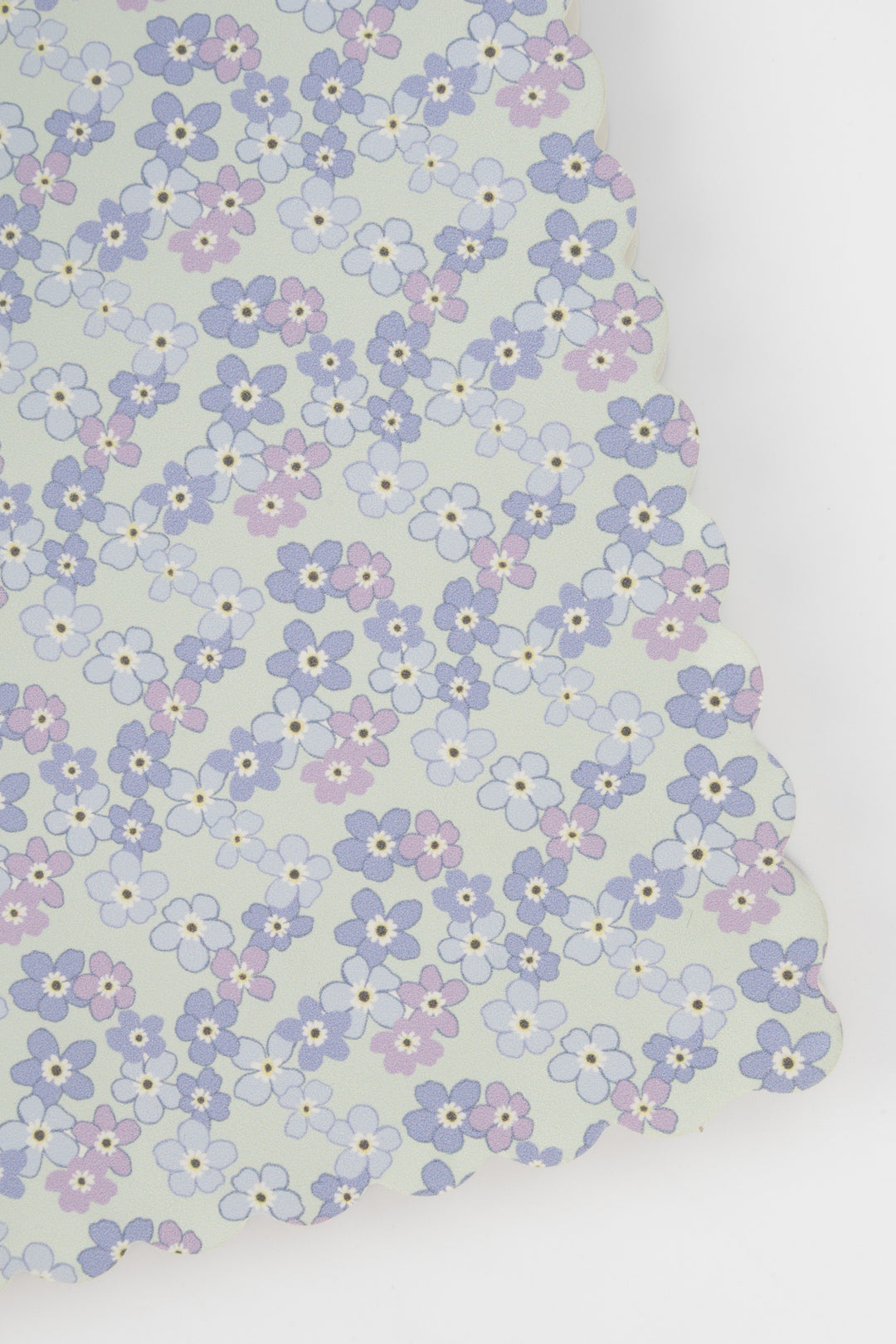 detail of a scalloped-edge notebook with an all-over small flower pattern in pastel colours
